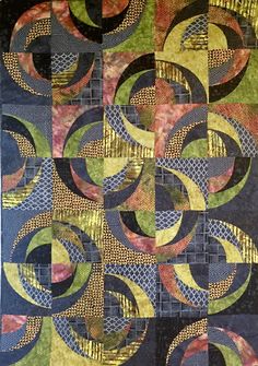 a quilt made with different colors and designs on it's sides, including circles