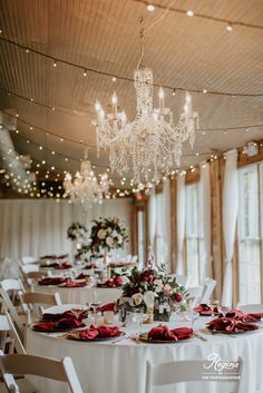 the tables are set with white linens and red napkins for an elegant wedding reception