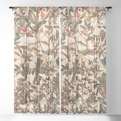 a window curtain with flowers and leaves on the outside, in front of a white wall