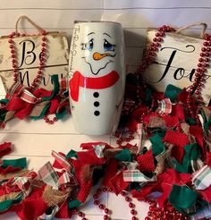 a snowman mug sitting on top of a table next to christmas decorations