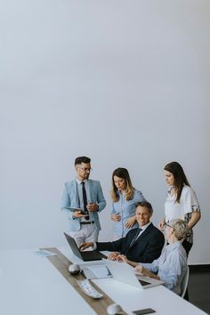 group of business people standing around a conference table