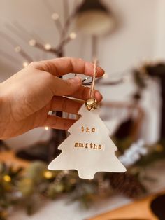 someone holding up a christmas tree ornament