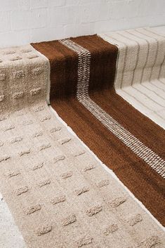 the carpeted stairs are lined with brown and white rugs