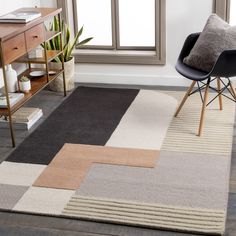 an area rug with various colors and shapes on the floor in front of a window