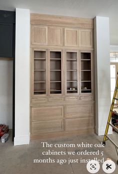 a ladder is in front of a cabinet with glass doors