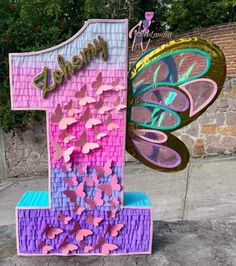 the number one sign is made out of paper and has butterflies on it, as well as