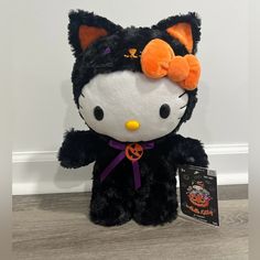 a hello kitty stuffed animal with an orange bow on it's head and eyes