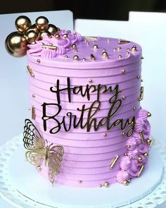 a birthday cake with purple frosting and gold decorations on the top that says happy birthday