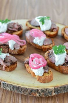 small sandwiches with meat and cream cheese on a wooden board, ready to be eaten