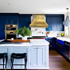 a kitchen with blue cabinets and white counter tops, gold hood over the stove island