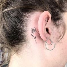 a woman's ear with a rose tattoo on her left side behind the ear