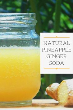 a glass jar filled with pineapple ginger soda next to a piece of bread on a table