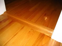 a wooden floor that has been cleaned and is in the process of being refinished