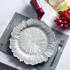 a silver plate sitting on top of a table next to a knife, fork and spoon