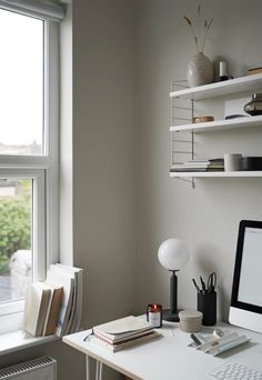 a desk with a computer, keyboard and mouse on it in front of a window