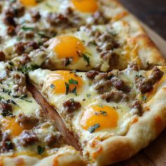 a pizza with cheese, sausage and eggs on it