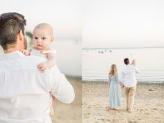 a man holding a baby in his arms while standing on the beach with other people