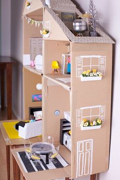 a cardboard doll house sitting on top of a table