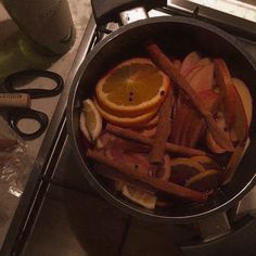 a pan filled with sliced up oranges and other fruit on top of a stove