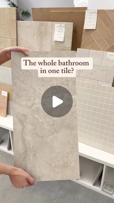 a person holding up a sign that says, the whole bathroom in one tile?