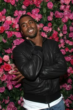 a man standing in front of pink flowers