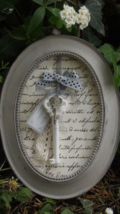 a plate with a bow on it sitting in the grass next to flowers and leaves