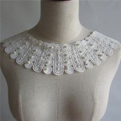 a white crocheted collar on a mannequin