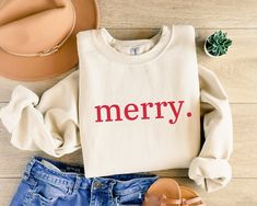 Elevate your Christmas style with your significant other with our Merry Sweatshirt! Made from a cozy 50% cotton, 50% polyester blend, it's the ideal choice for comfort and style. This sweater's medium-heavy fabric keeps you warm without feeling bulky. With a loose fit and a ribbed knit collar that retains its shape, it's perfect for any festive occasion or to lounge in. **COLOURS** White Sweatshirt - Red text Ash Sweatshirt - Red text Black Sweatshirt - Red text  Sand Sweatshirt - Red text  Spor Cute Christmas Sweaters, Tshirt Details, Cute Winter Sweaters, Sweater Print, Sweatshirt Details, Christmas Crewneck, Merry Christmas Gifts, Merry Christmas Shirts, Holiday Sweatshirt