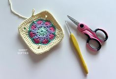 a crocheted pot holder with scissors and yarn