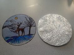 two plates sitting on top of a table covered in frosty paper and painted with animals