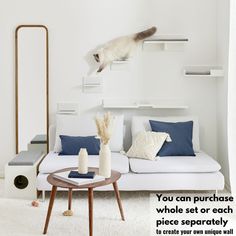 a cat jumping over a white couch in a living room