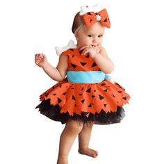 a baby girl dressed in an orange and black costume