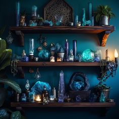 shelves with candles, vases and other decorative items on them against a blue wall