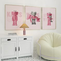 two pink teddy bears are hanging on the wall next to a white cabinet and lamp