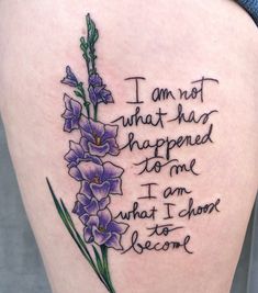 a woman's thigh with purple flowers and the words i am not what she happened to me