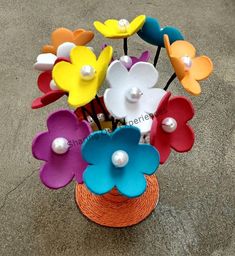 a vase filled with colorful flowers on top of a cement floor next to a sidewalk