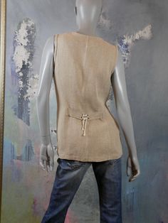 This long linen vest is a warm beige color, has a V neckline, and closes in the front with five buttons. The 1990s European vintage waistcoat features 8-inch slits on the front sides that close partially with crisscross laced rope cords, and that same cord is used to tie the half-belt on the back. Bust = 38 inches (96.52cm) Vest Length = 29 inches (73.66cm) Brand label: di Roberto Size: 10 US, 14 UK Material: Linen Condition: Near Mint (clean, soft, and supple, with no stains, tears, wear spots, Beige V-neck Vest With Buttons, Summer Beige Vest With Buttons, Fitted Beige Linen Vest, Vintage Waistcoat, Mad Men Dresses, Long Waistcoat, Formal Cocktail Party, Linen Vest, Dark Magenta