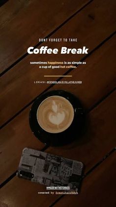 a cup of coffee sitting on top of a wooden table