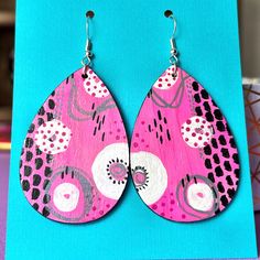 Abstract pink and white doodles. A one-of-a-kind original design hand-painted onto lightweight wooden earrings, perfect for parties, festivals, or any other time you want a pop of color.  From top of hook to bottom of earring, they measure about 3 inches long.  The first photo shows the front design and the second photo shows the backs.  Triple-coated with gloss varnish to protect the artwork.  We use hypoallergenic surgical steel wires. Clear plastic earring backings are included.  Each pair wi Hand Painted Earrings Wood, Festival Earrings, Abstract Earrings, Hand Painted Earrings, Sparkly Jewelry, Painted Earrings, Painted Jewelry, Art Earrings, Beaded Earrings Diy