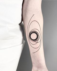 a woman's arm with a black and white tattoo design on the left forearm