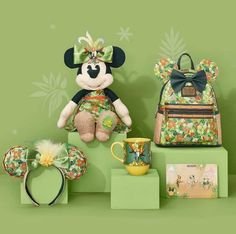 a minnie mouse stuffed animal sitting on top of a shelf next to a backpack and coffee cup