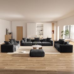 a large living room with black couches and white walls