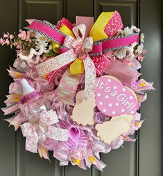 a wreath with pink, yellow and white decorations