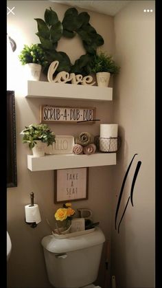 there is a toilet in the bathroom with plants on the shelves above it and other decorations