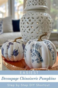 some white pumpkins sitting on top of a wooden tray with blue and white designs