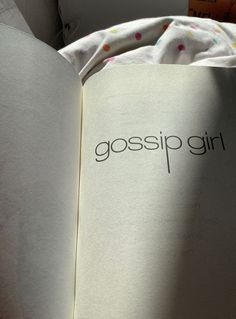 an open book with the word gossip girl written in black on it's cover