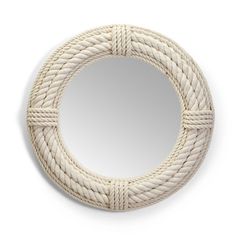 a round white rope mirror hanging on a wall