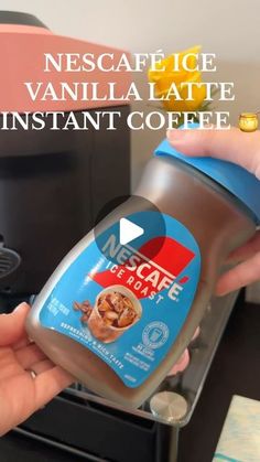 someone is holding a coffee cup in front of an espresso machine with the words nestle vanilla latte instant coffee on it