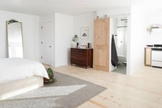 a bedroom with white walls and wood floors