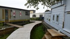 there is a wooden walkway going up to the house and next to it is a picnic table with benches